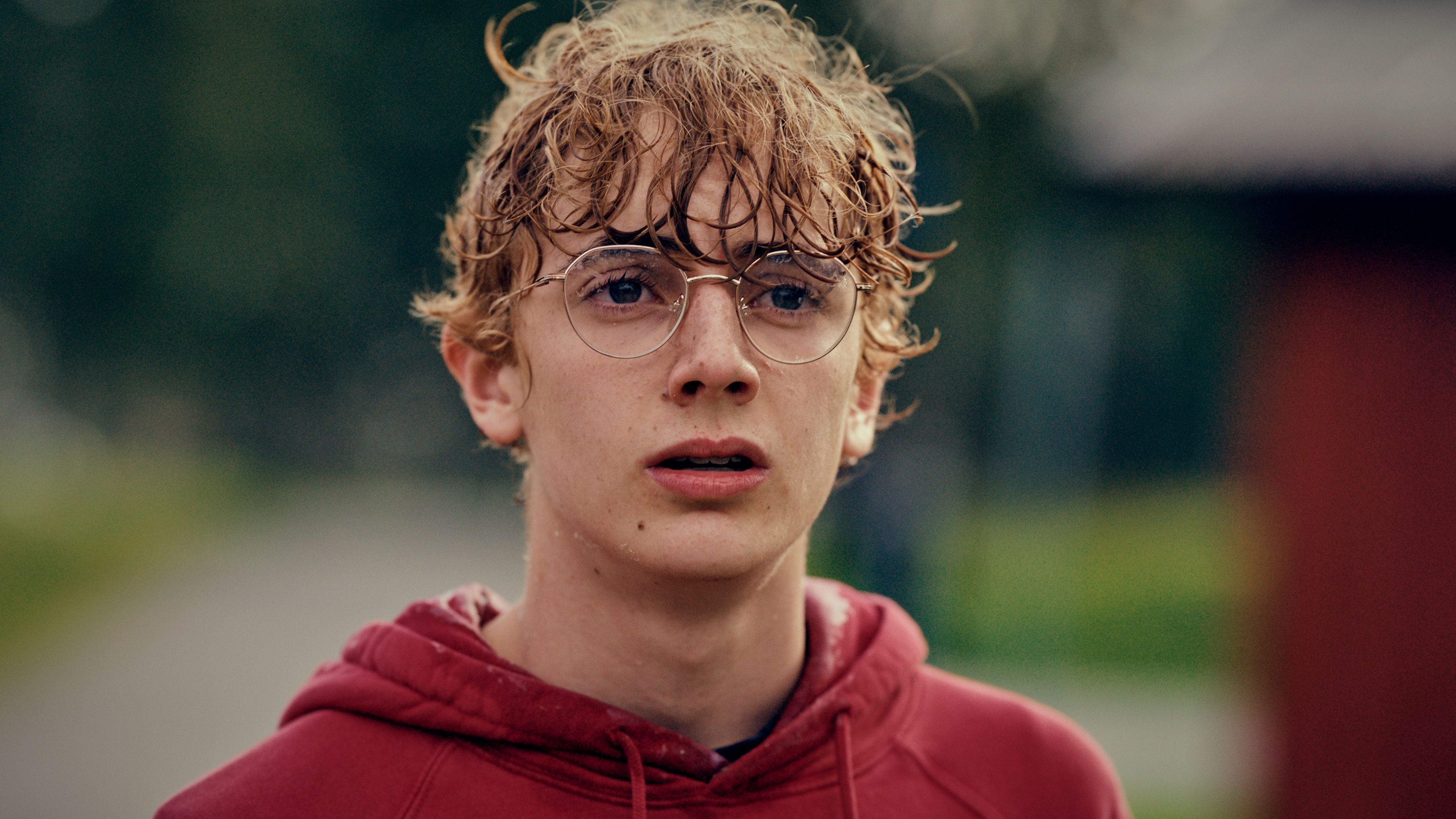 En pojke med blött krulligt hår ser orolig ut